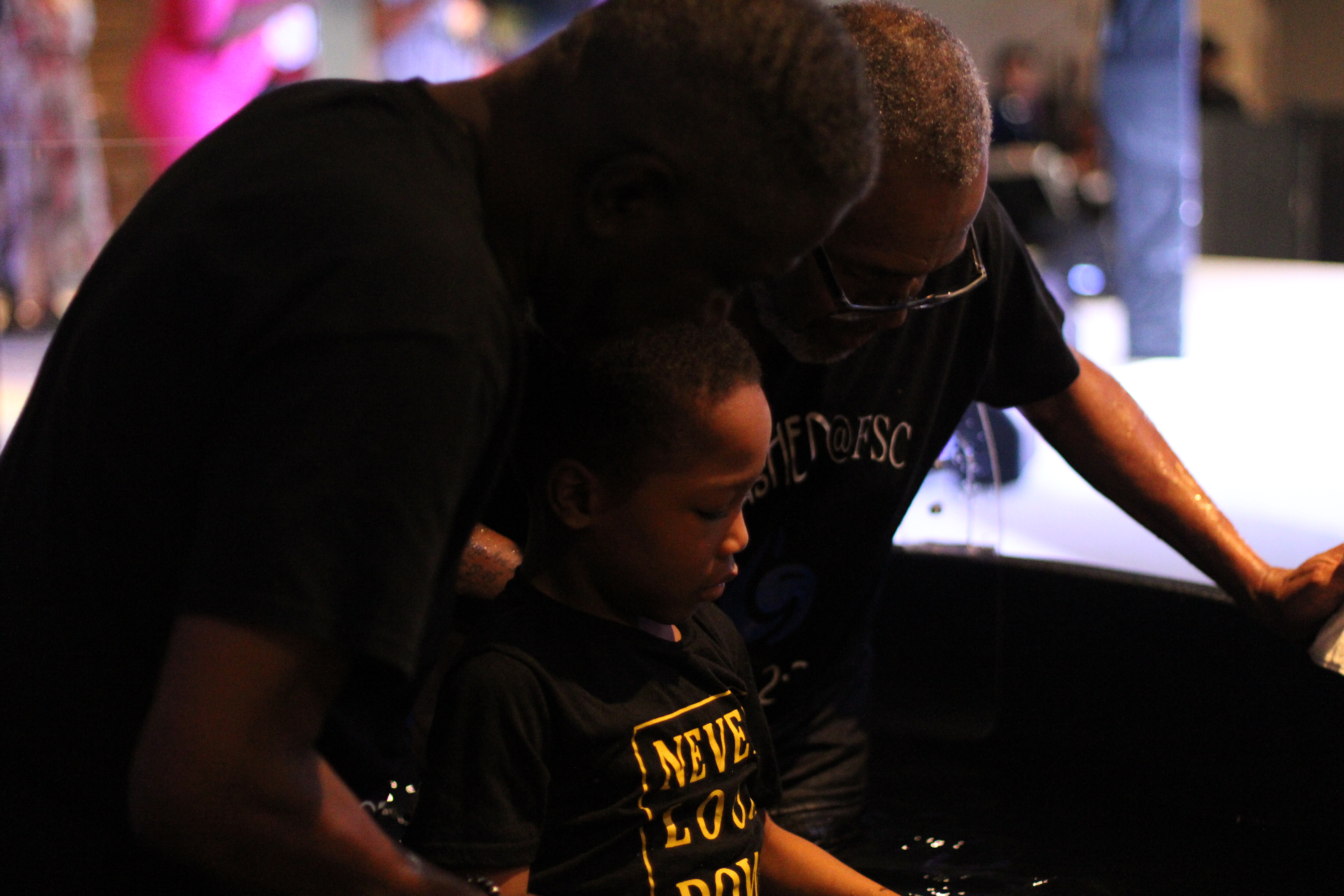 Prayer over a child at the baptism pool