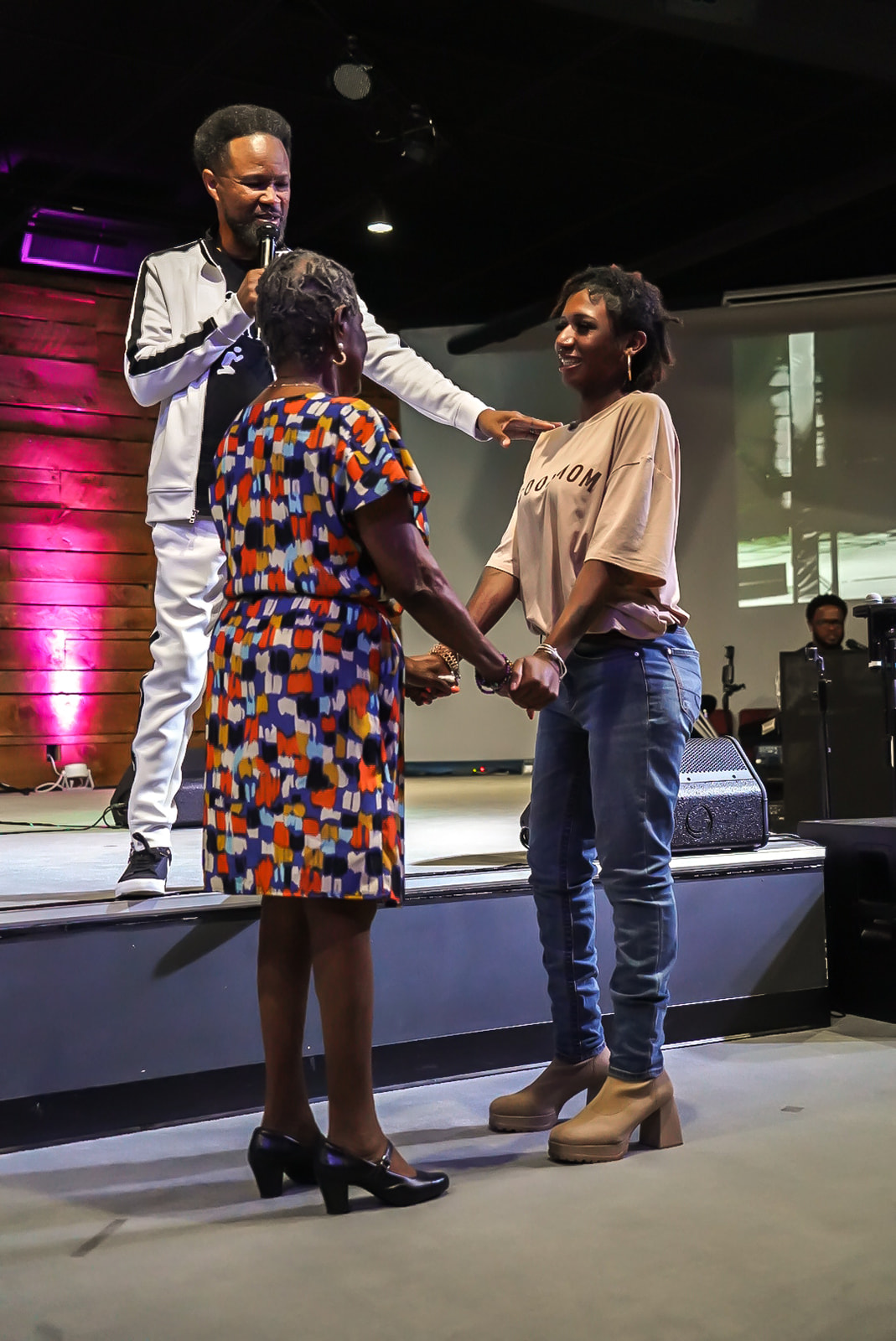 Apostle Craig praying over a mother and daughter