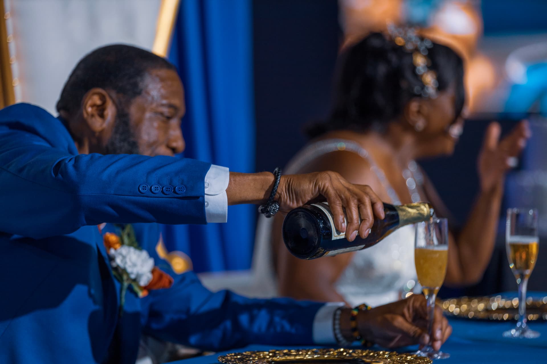 Groom pouring champagne at the head table
