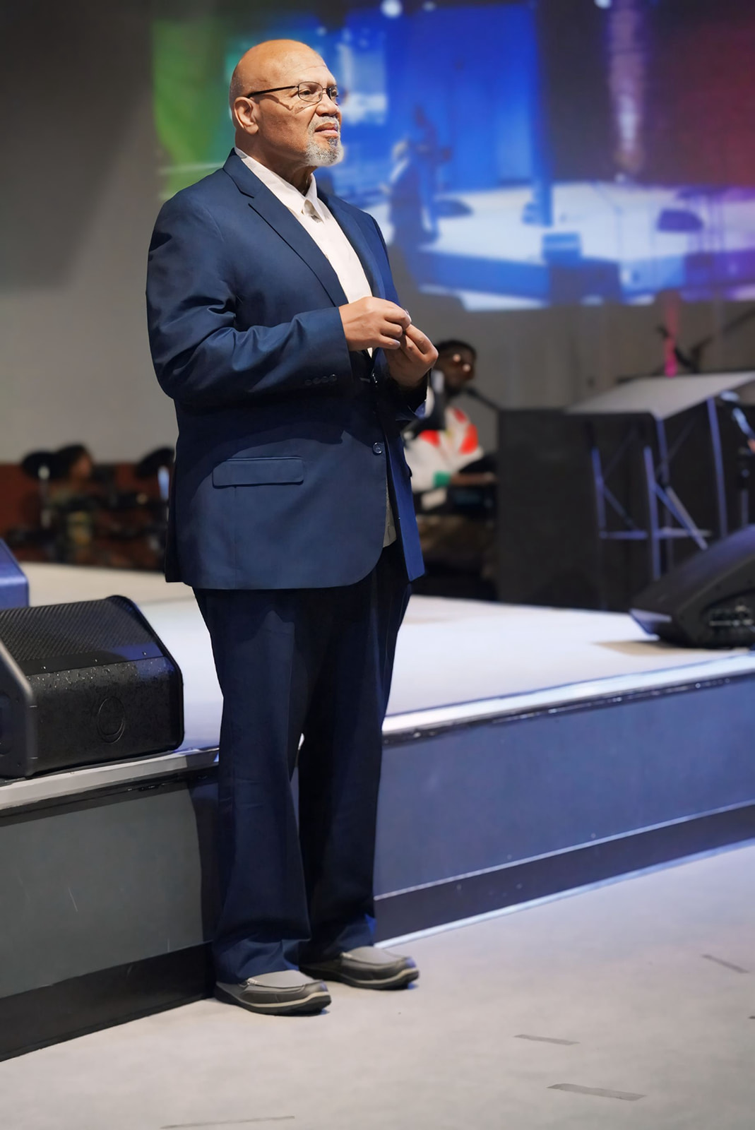 Apostle Craig standing in a blue suit before service