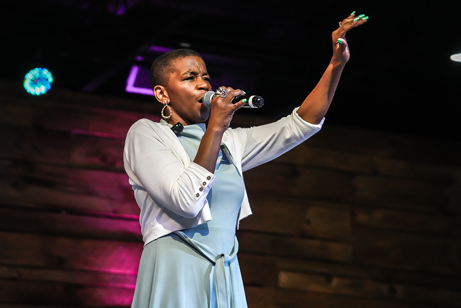 Worship leader singing with hand raised