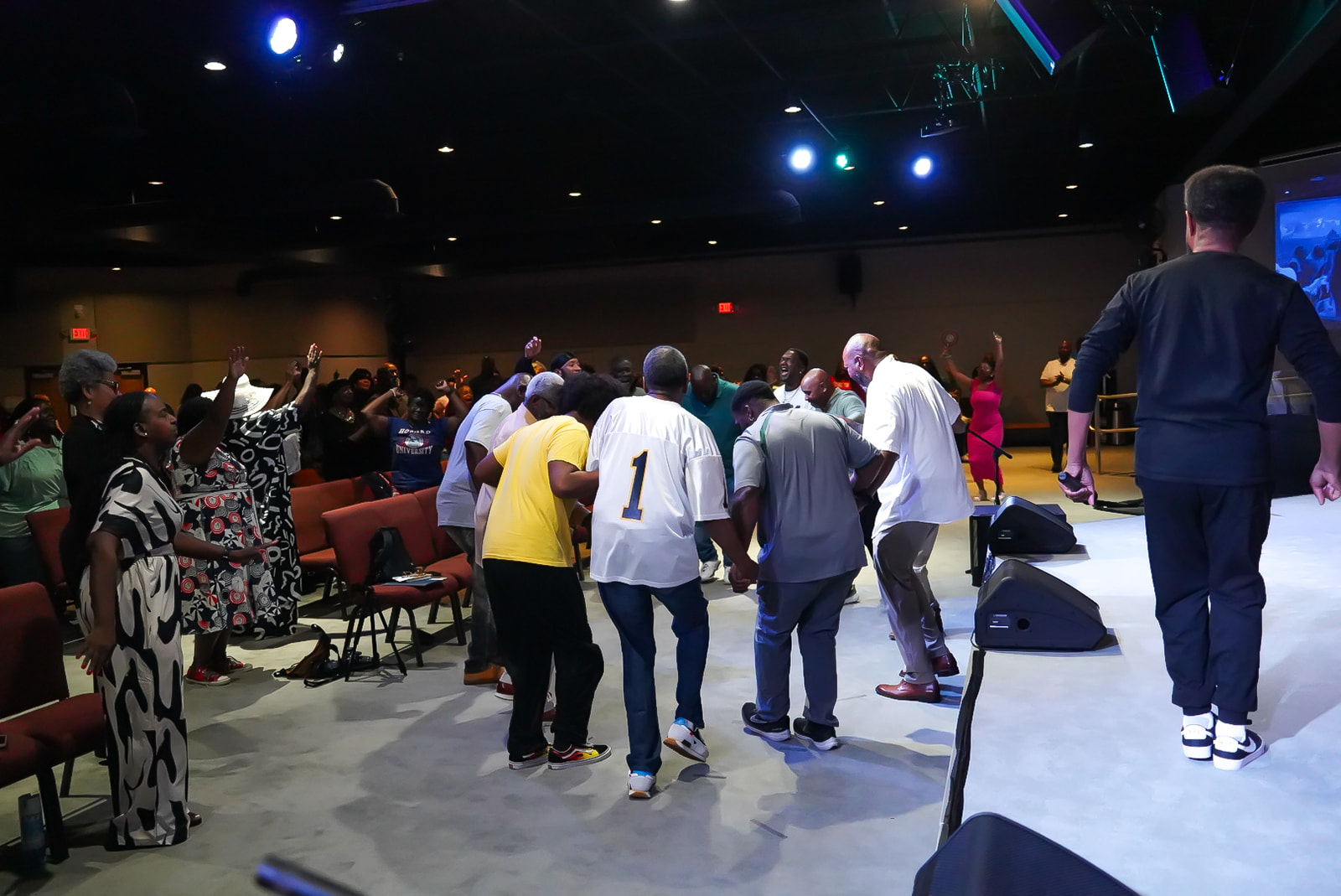 Men gathering in a circle of prayer