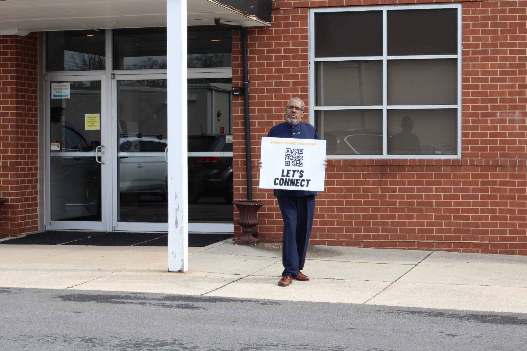 Let's Connect greeter outside the church