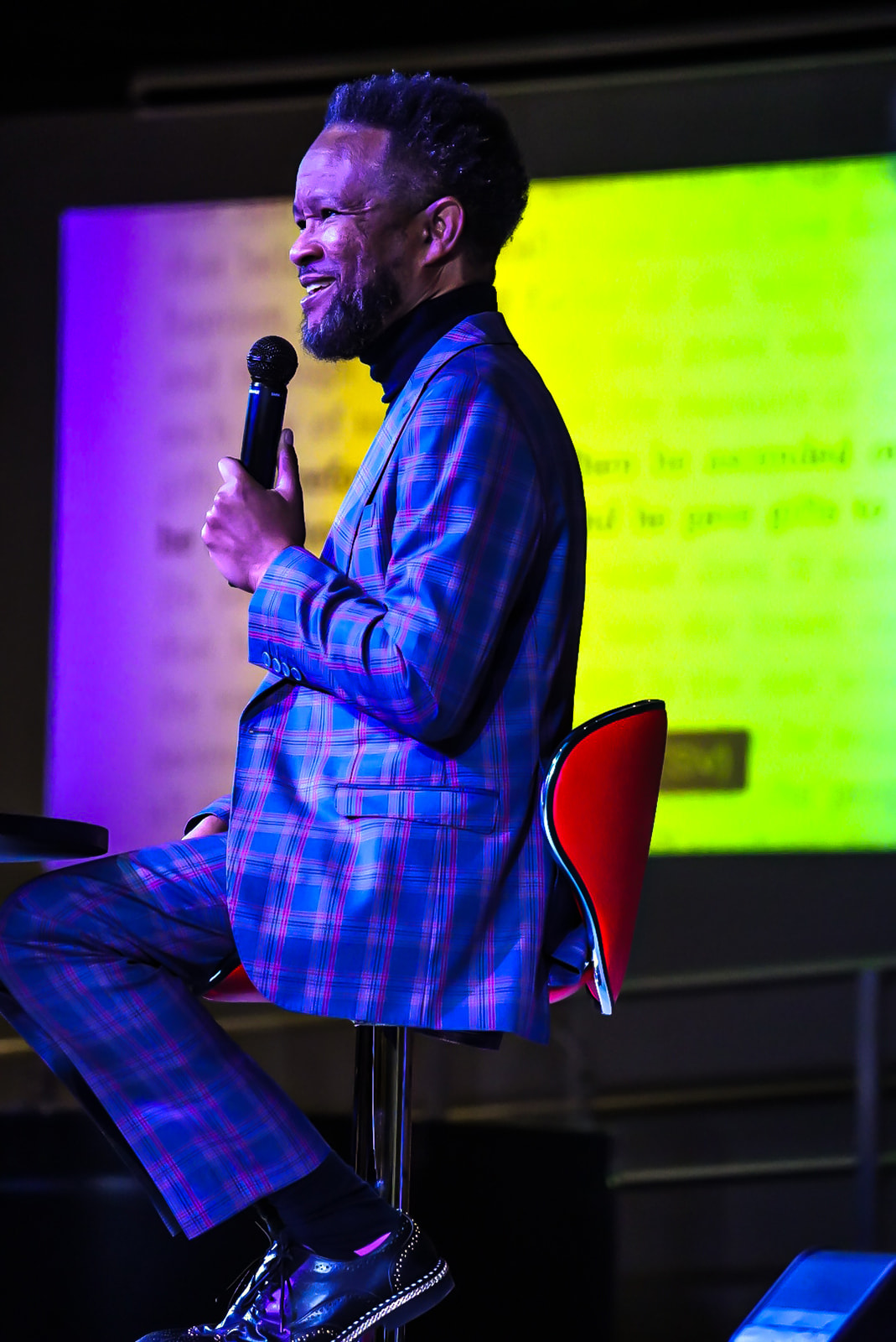 Apostle Craig teaching in a plaid suit